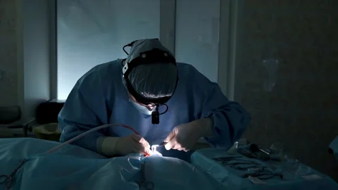 Surgeon performing delicate operation under focused light Stock Footage 306167245