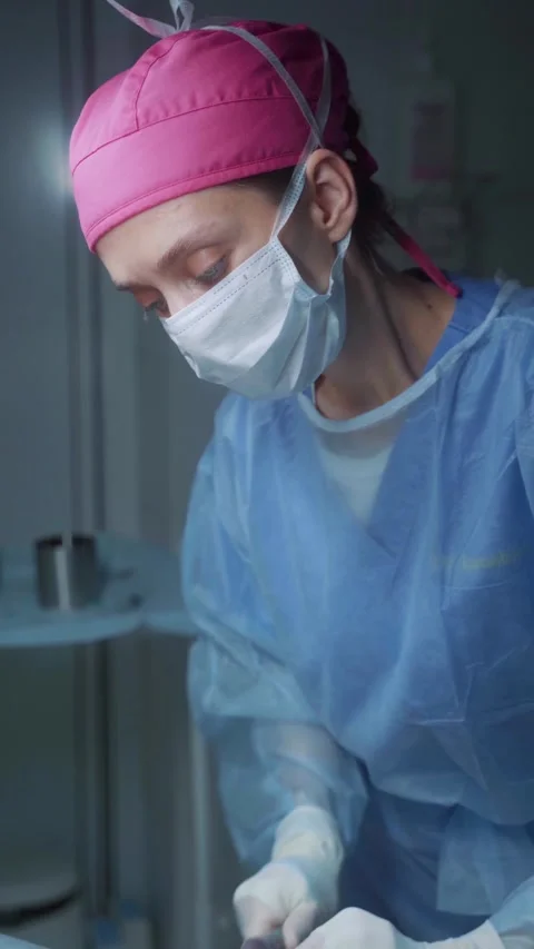 Surgeon performing a delicate procedure in a modern operating room environment Stock Footage 295864097