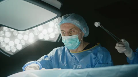 Surgeon Performing Operation on Patient in Operating Room Stock Footage 331363542