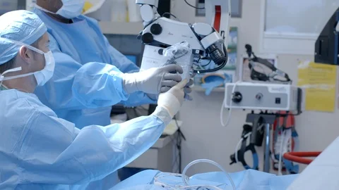 Surgeon Performing Surgery with a Microscope Stock Footage 127196149