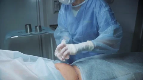Surgeon performs delicate procedure on patient in surgical room Stock Footage 295864073