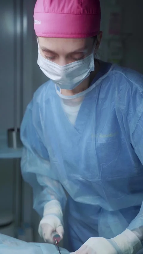 Surgeon performs intricate procedure in well-equipped operating room during 스톡 동영상 295864397