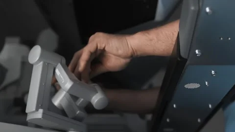Surgeon performs operation on patient in virtual reality controlling robotic arm Stock Footage 242367678