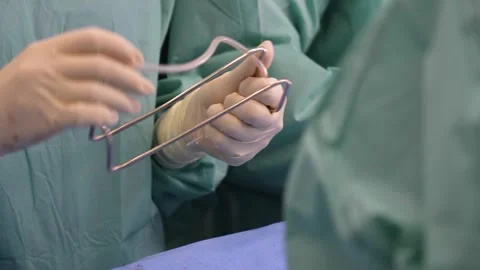 A surgeon prepares an instrument during surgery. Stock Footage 292007628