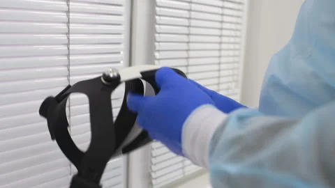 Surgeon prepares for surgery and puts on surgical glasses Stock Footage 100472345