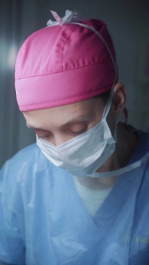 Surgeon preparing for a critical procedure in a sterile operating room Stock Footage 295864375