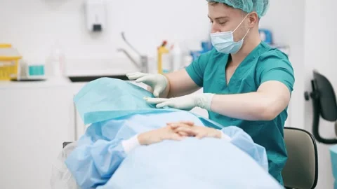 Surgeon preparing a patient for surgery in an operating room Vídeo Stock 341263697