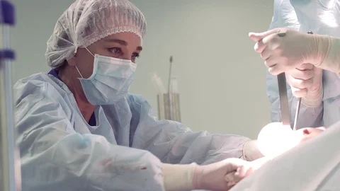 Surgeon, Professor, intently doing her job. Surgeon and surgical team are Stock Footage 81490523