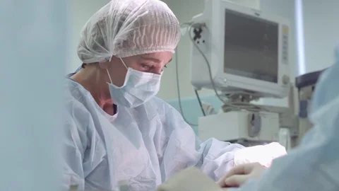 Surgeon, Professor, intently doing her job. Surgeon and surgical team are Stock Footage 81490782