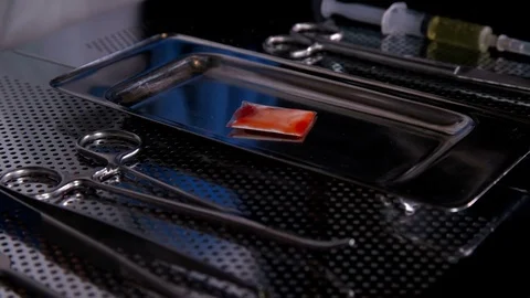 The surgeon puts a small bag of drugs on the tray after surgery Stock Footage 80993650