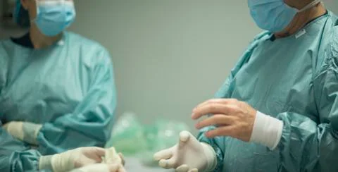 Surgeon putting on gloves Stock Photos
