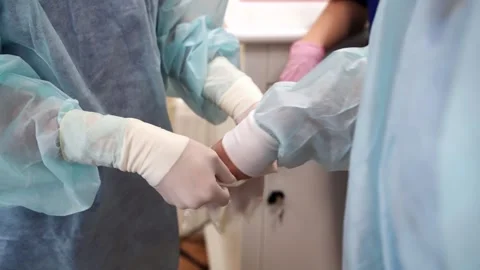 Surgeon putting protective Gloves on Before Operation. Close up view . Stock Footage 146391519