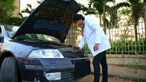 Surgeon standing at road while car hood open Stock Footage 278022891