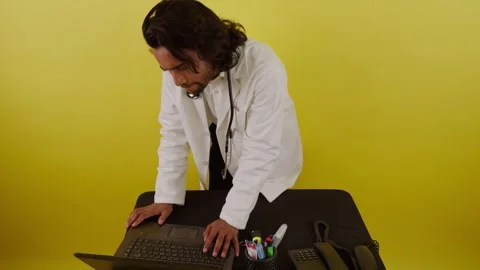 Surgeon with stethoscope reviews data reflecting on screen Stock Footage 310285319