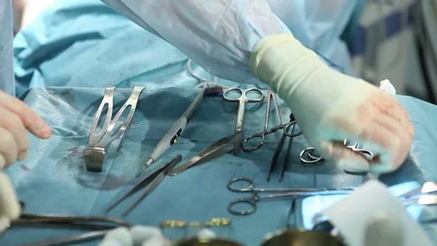 Surgeon taking surgical tools. Surgeon's teams operating in operating room Stockbeeldmateriaal 72738797