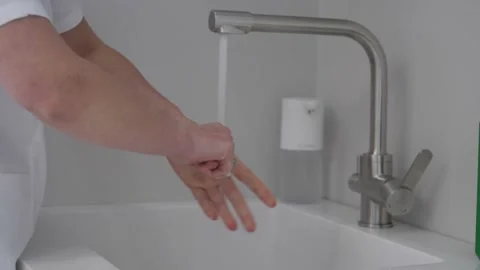 The surgeon thoroughly washes his hands with soap before surgery. Stock Footage 162242653