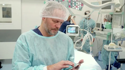Surgeon uses tablet at the surgery room Video stock 73590578