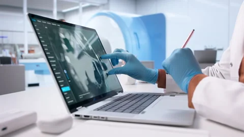 Surgeon Using Computer To Analyze X-ray Images Stock Footage 328712560