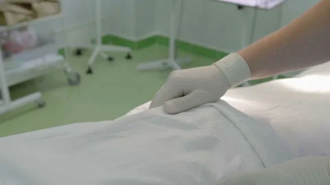 Surgeon in white protective rubber gloves, palpates the patient on the table in Stock Footage 114160225
