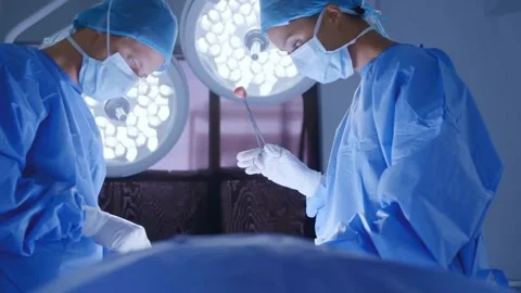 Surgeons in Action Focused Operation under Medical Lighting Stock Footage 307585680