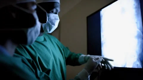 Surgeons Analyze X-Ray Image on Monitor Before Procedure in Operating Room Stock Footage 314303649