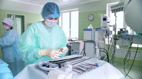 Surgeon's assistant prepares tools for surgery Stock Footage 150890182