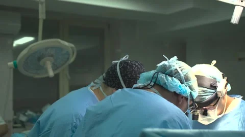 Surgeons bent over the operating table during surgery. Stock Footage 286987978