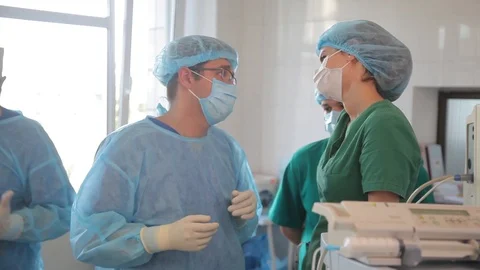 Surgeons confer in the operating room. communication of doctors during the opera Stock Footage 99200040