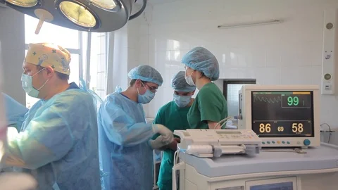 Surgeons confer in the operating room. communication of doctors during the opera Video stock 99200043