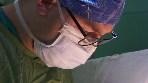 Surgeon's face. panorama. surgeon's hands stitch the wound after heart operation Vídeos de archivo 95941117