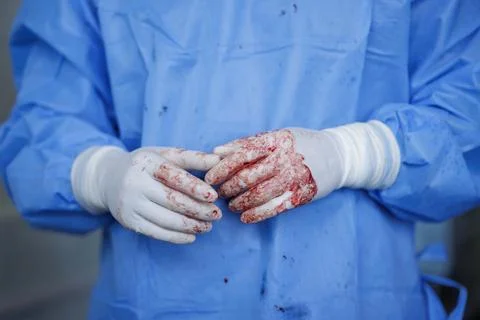 Surgeon's Hands in Gloves After Complex Surgery Procedure Stock Photos
