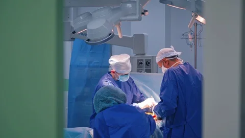 Surgeons making operation. Teamwork of doctors in medical uniform perform Stock Footage 125895191