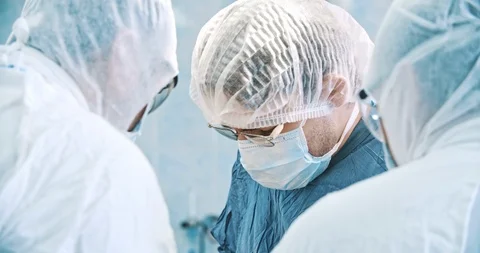 Surgeons in masks performing an operation in operating theatre. Medicine Stock Footage 121097473