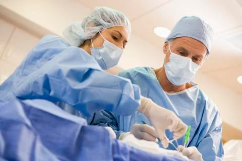Surgeons Operating On Patient Stock Photos
