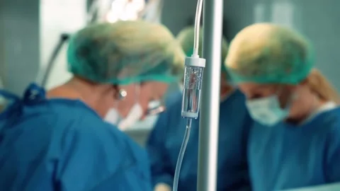Surgeons in the operating room perform an operation on a patient. A complex Stock Footage 219427070