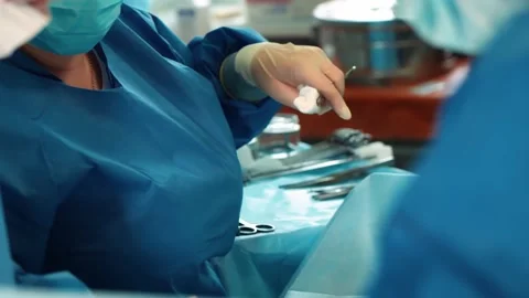 Surgeons in the operating room perform an operation on a patient. A complex Stock Footage 219427166
