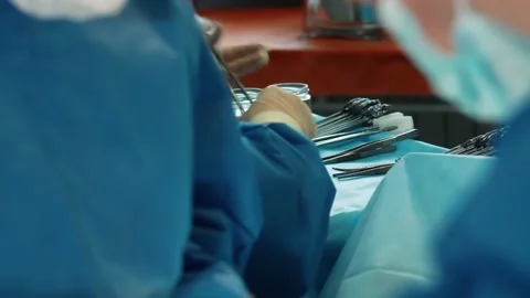 Surgeons in the operating room perform an operation on a patient. A complex Stock Footage 219427238