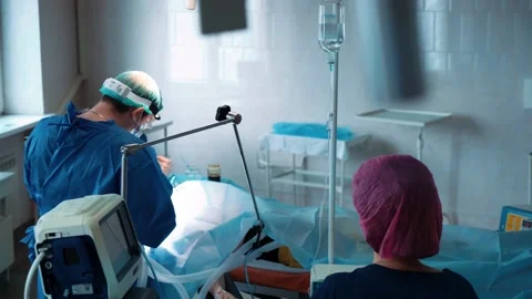 Surgeons in the operating room perform an operation on a patient. A complex Stock Footage 220582506