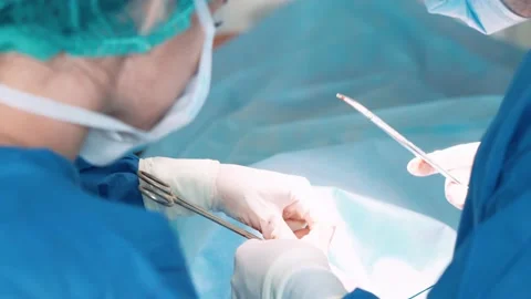 Surgeons in the operating room perform an operation on a patient. A complex Stock Footage 220582520