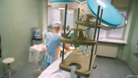 Surgeons in the operating room perform an operation on a patient. A complex Stock Footage 221276973