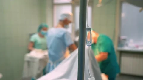 Surgeons in the operating room perform an operation on a patient. A complex Stock Footage 221276992