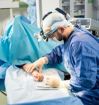 Surgeons in the operating room trying to save the patient's hand. Stock Photos