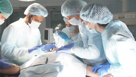 Surgeons perform a complex operation to save a human life at hospital Stock Footage 99783850