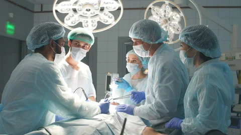 Surgeons perform a complex operation to save a human life at hospital Stock Footage 99785245
