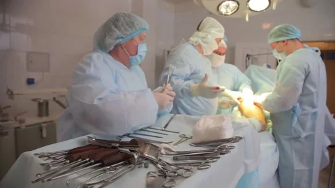 Surgeons perform an operation. the patient is under anesthesia. Stockbeeldmateriaal 135309871