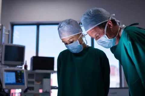 Surgeons performing operation in operation theater Photos