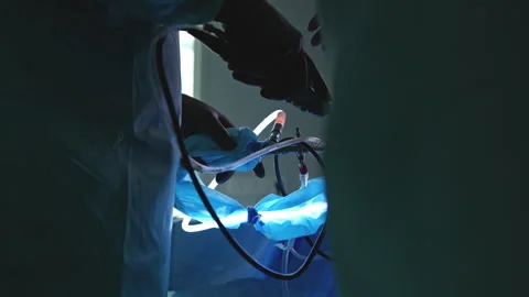 Surgeons Performing an Operation Using Advanced Laparoscopic Tools in a Dark Stock Footage 296929843