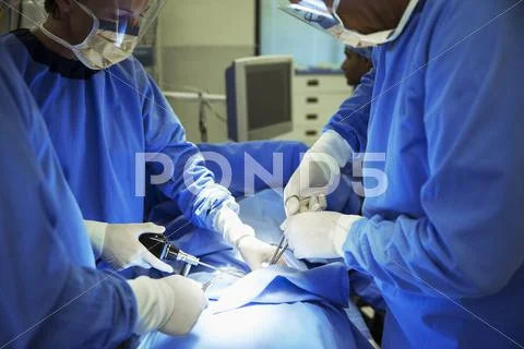 Surgeons Performing Surgery In Operating Room
