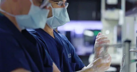 Surgeons Scrubbing in with surgical gloves Stock Footage 146607255