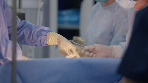 Surgeons sew up patient wound using medical tools Stock Footage 252719806